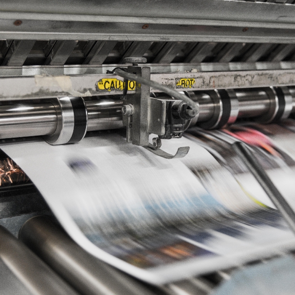 AI for identifying News Publisher A news printer with a fast moving paper going through it